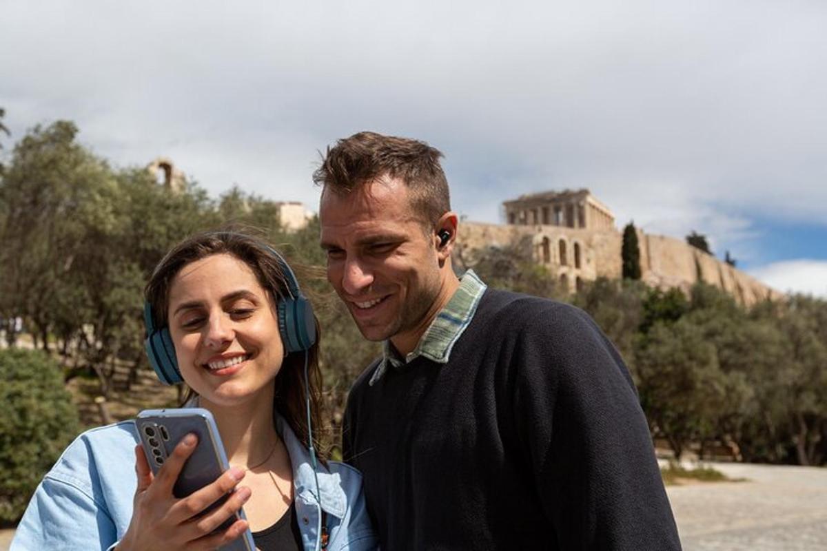 a man and woman wearing headphones taking a picture with a cell phone