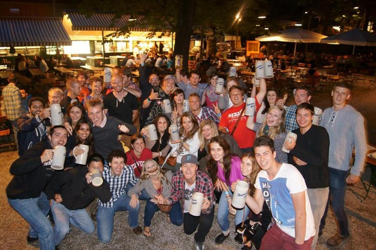 een groep mensen die poseren voor een foto terwijl ze hun kopjes omhoog houden