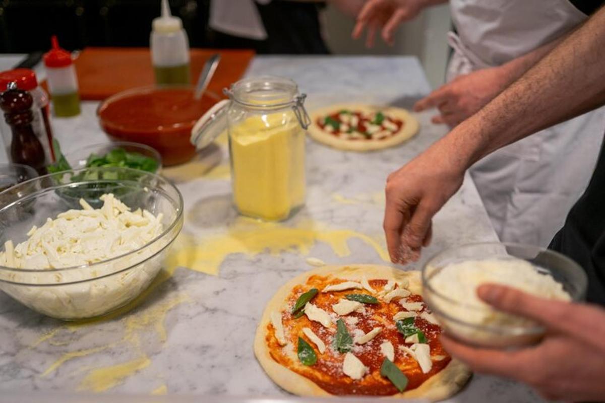 un grup de persones fent pizzes a la taula