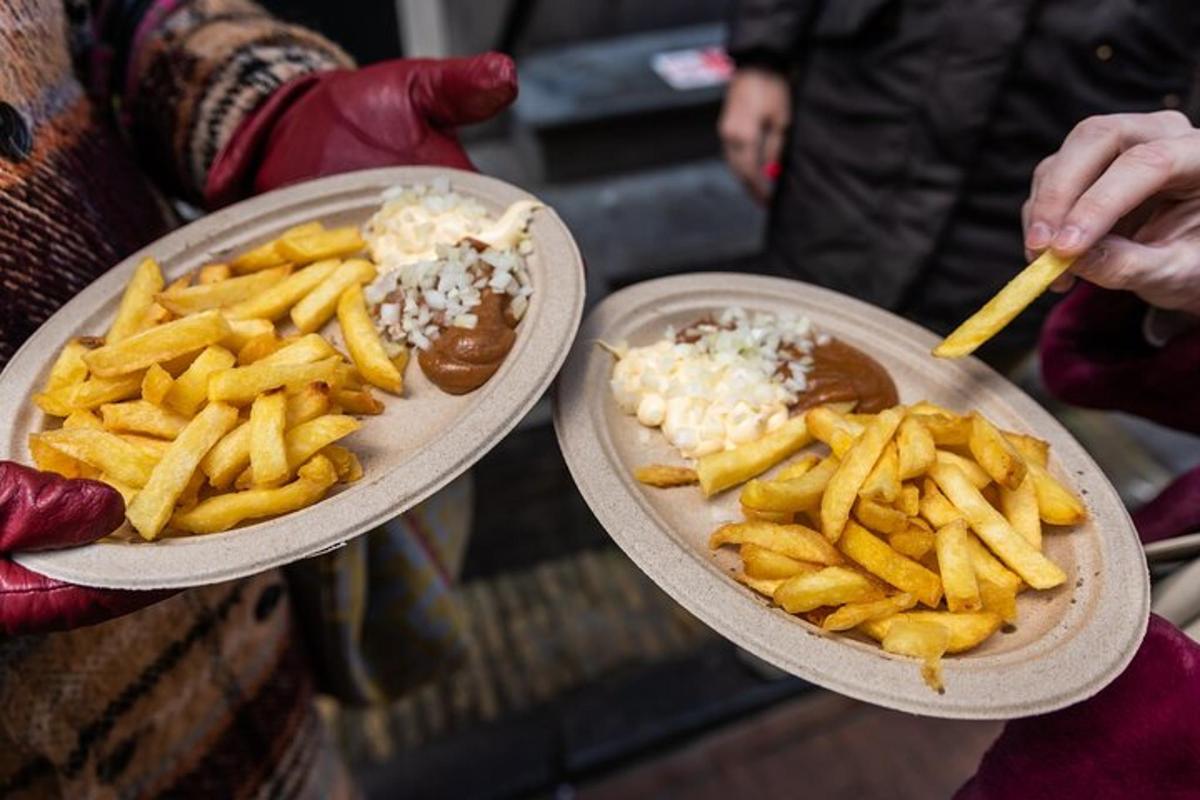 une personne tenant deux assiettes de nourriture avec des frites