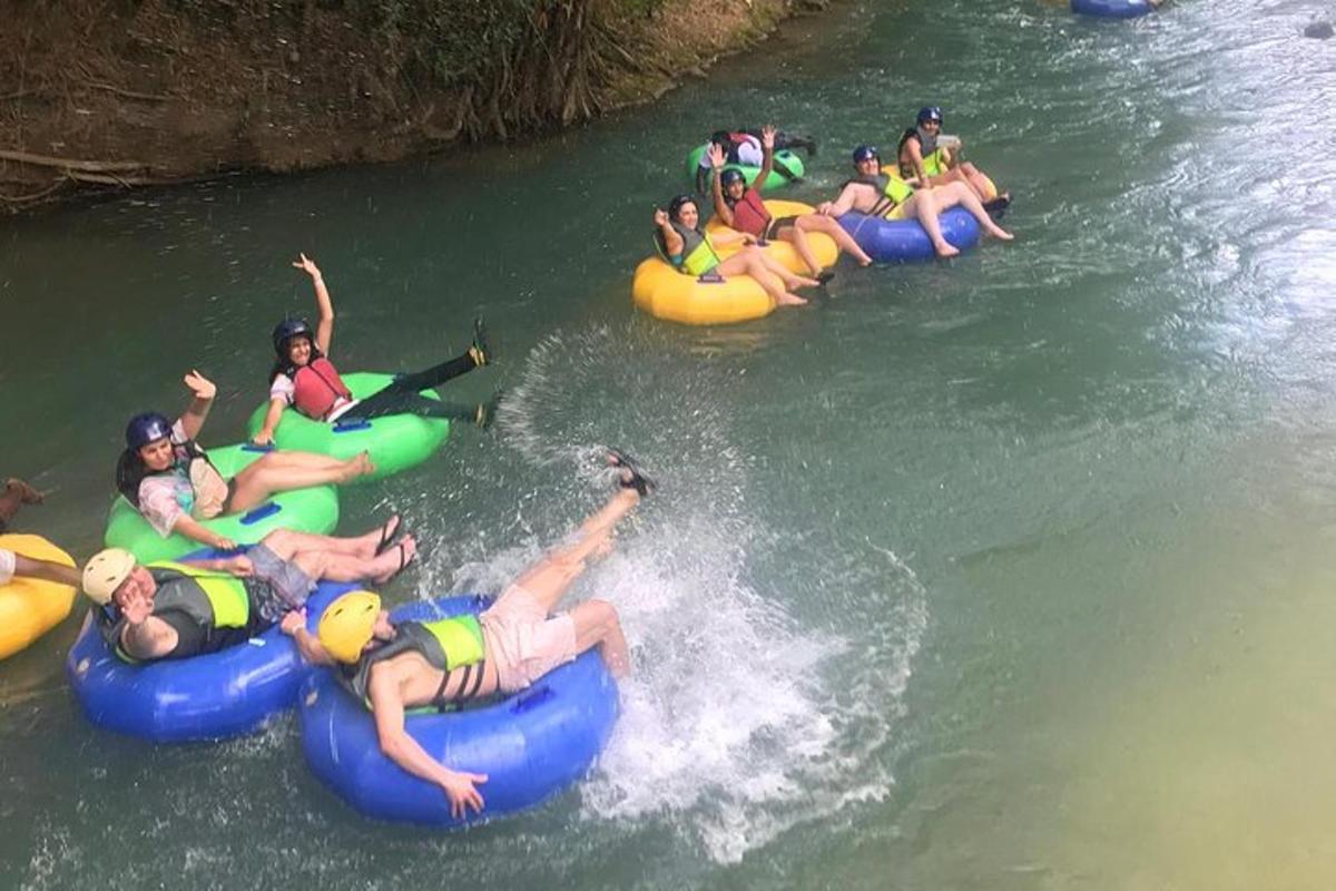 eine Gruppe von Menschen, die auf Schläuchen einen Fluss hinunter raften