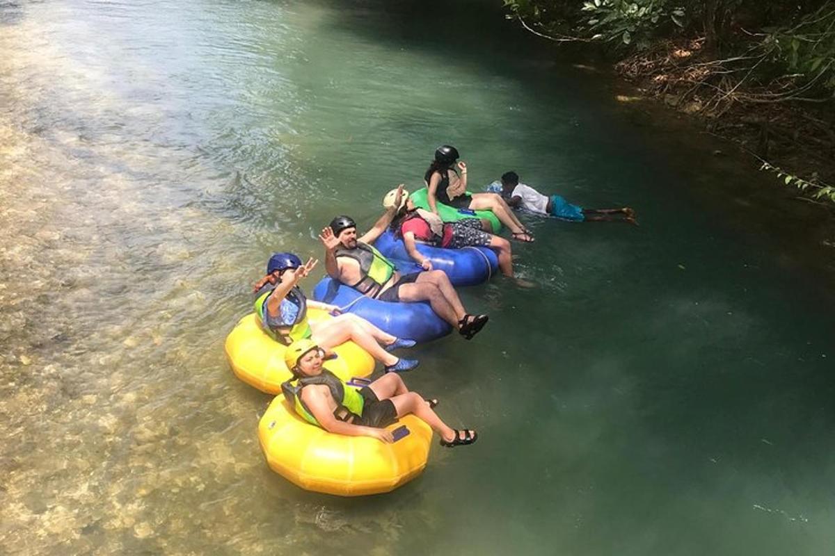 eine Gruppe von Menschen, die auf Schläuchen im Wasser reiten