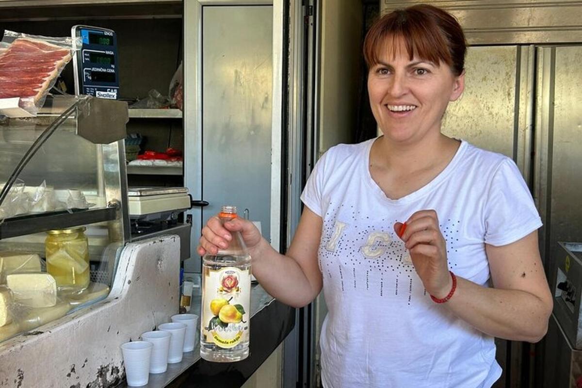 o femeie care stă în bucătărie ținând o sticlă