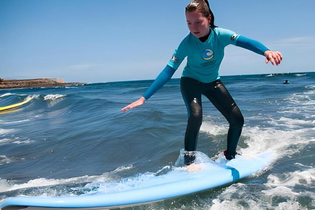 isang batang babae na nakasakay sa isang surfboard sa karagatan