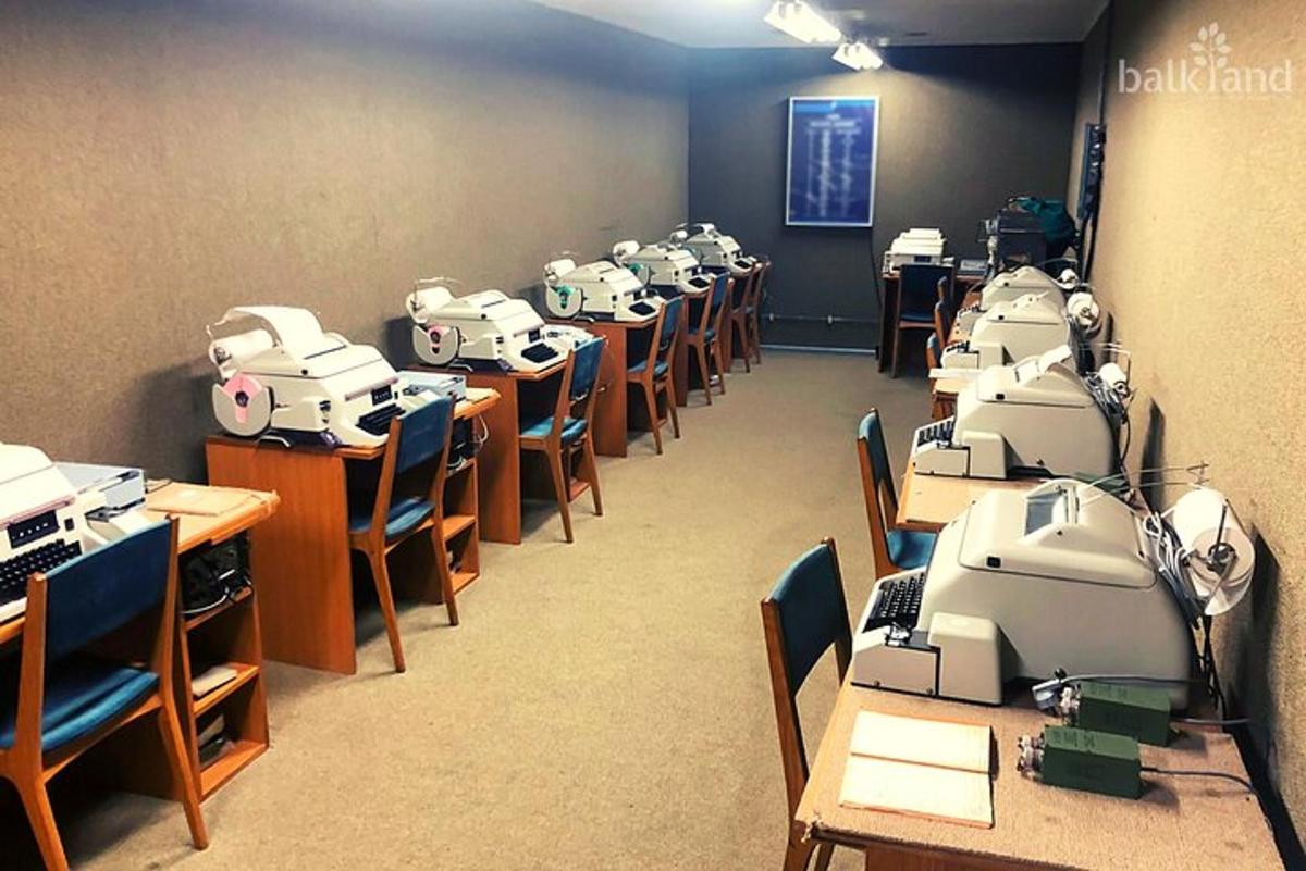 a classroom with a row of desks with machines on them