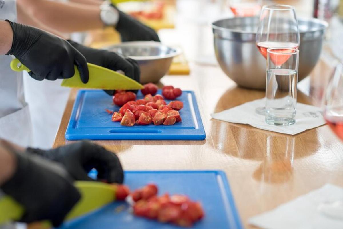 une personne portant des gants noirs coupant des fraises sur une table