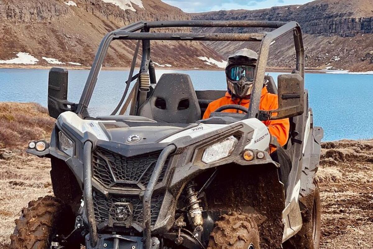 a man in an atv parked next to a lake