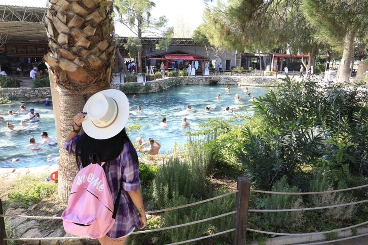 eine Frau mit Hut steht neben einem Swimmingpool