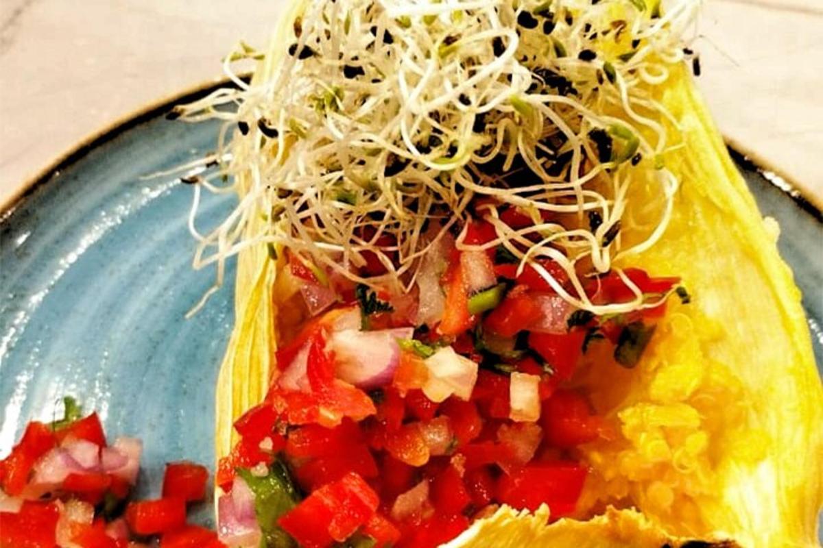 un taco con salsa e formaggio su un piatto blu