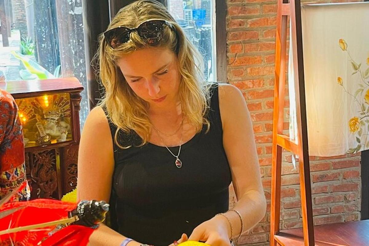 žena v černé košili krájející pomeranč
