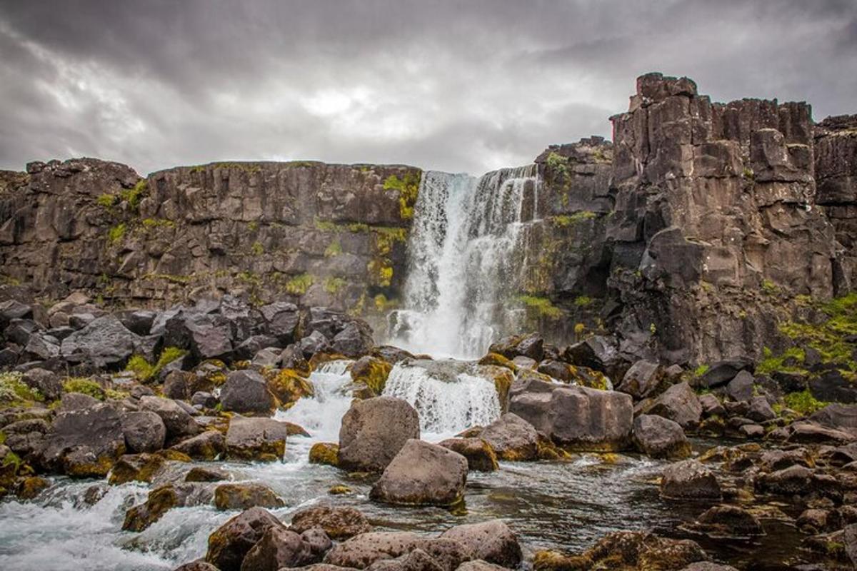 a waterfall on the side of a mountain with rocks