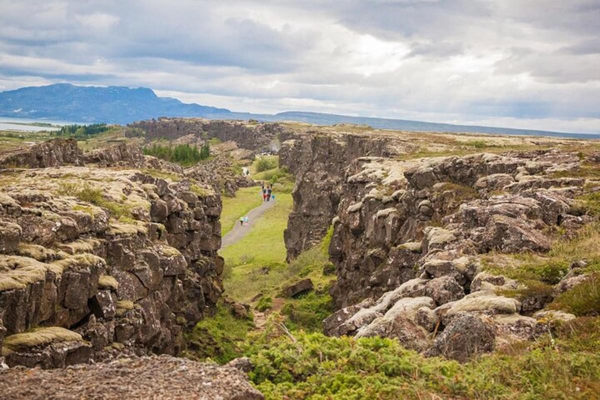a group of people walking on a path between rocks