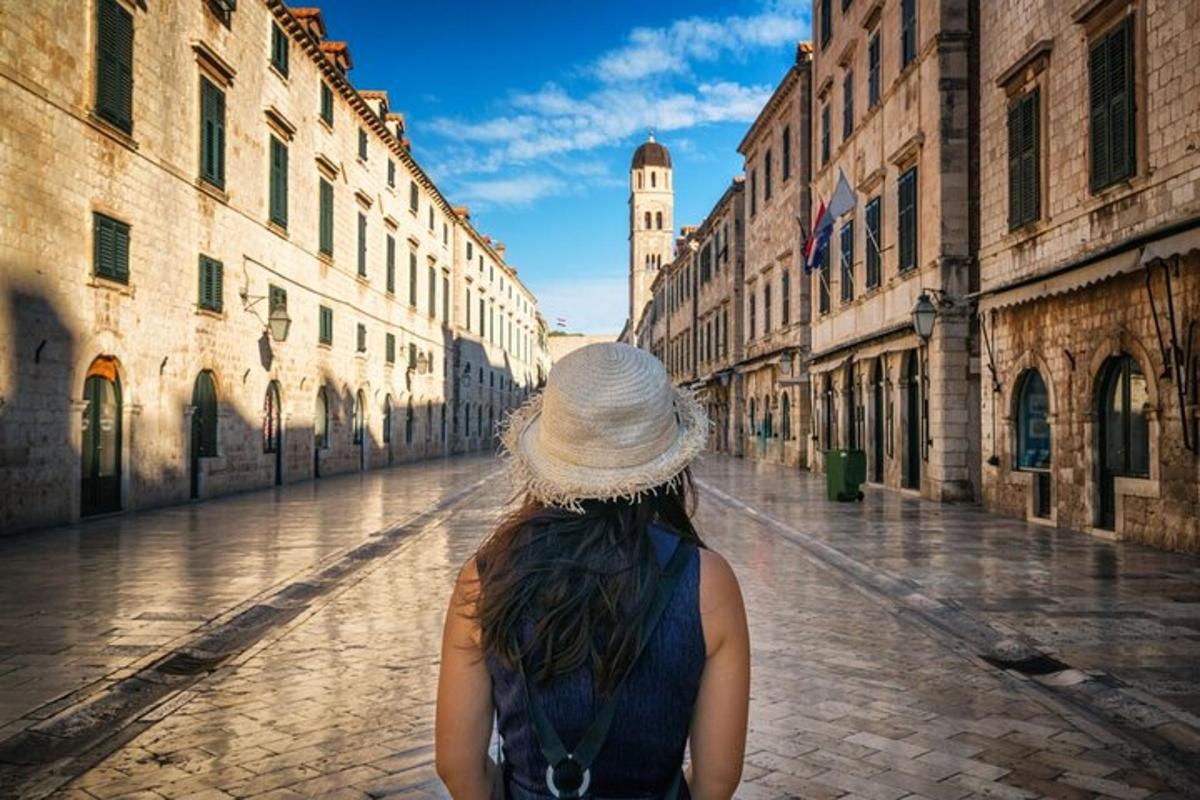 μια γυναίκα με καπέλο περπατάει σε έναν δρόμο