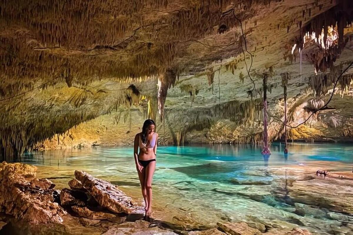 a woman standing in the water in a cave