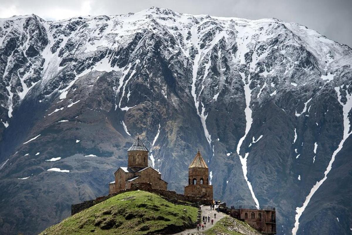 a castle on a hill with a snow covered mountain