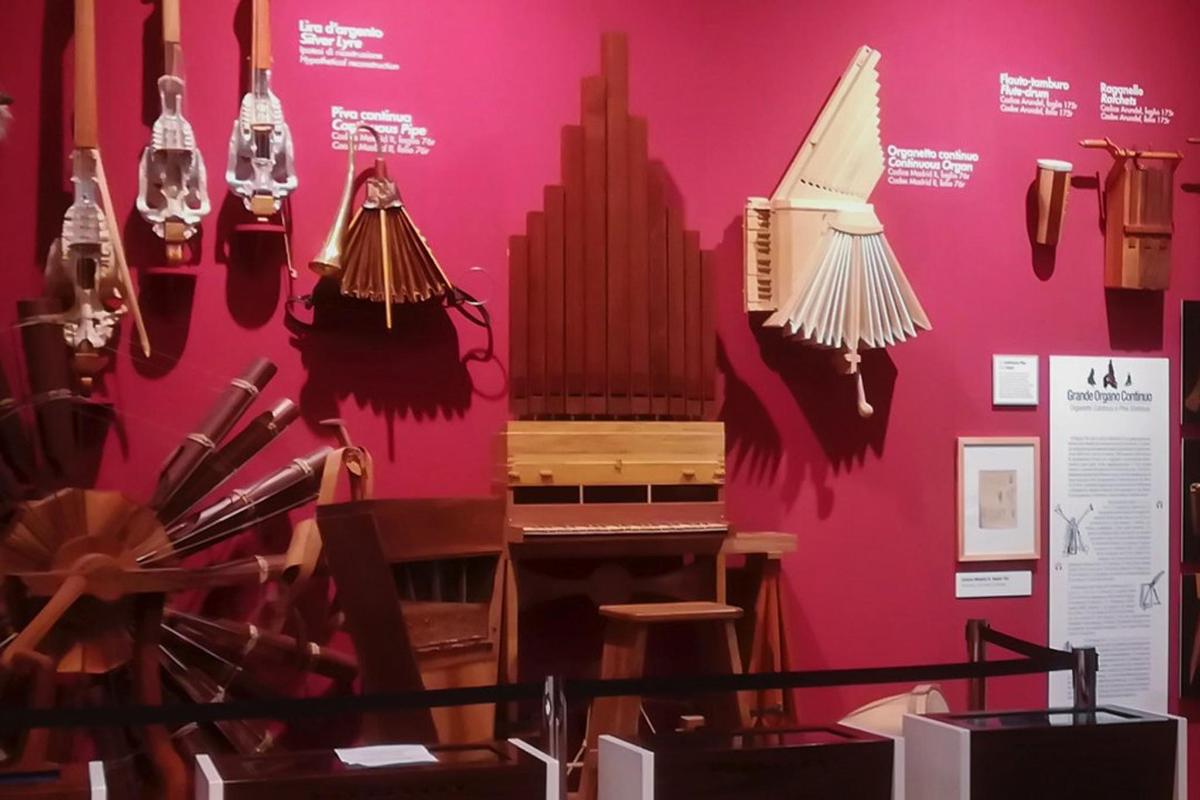 una mostra in un museo con un pianoforte e lampadari