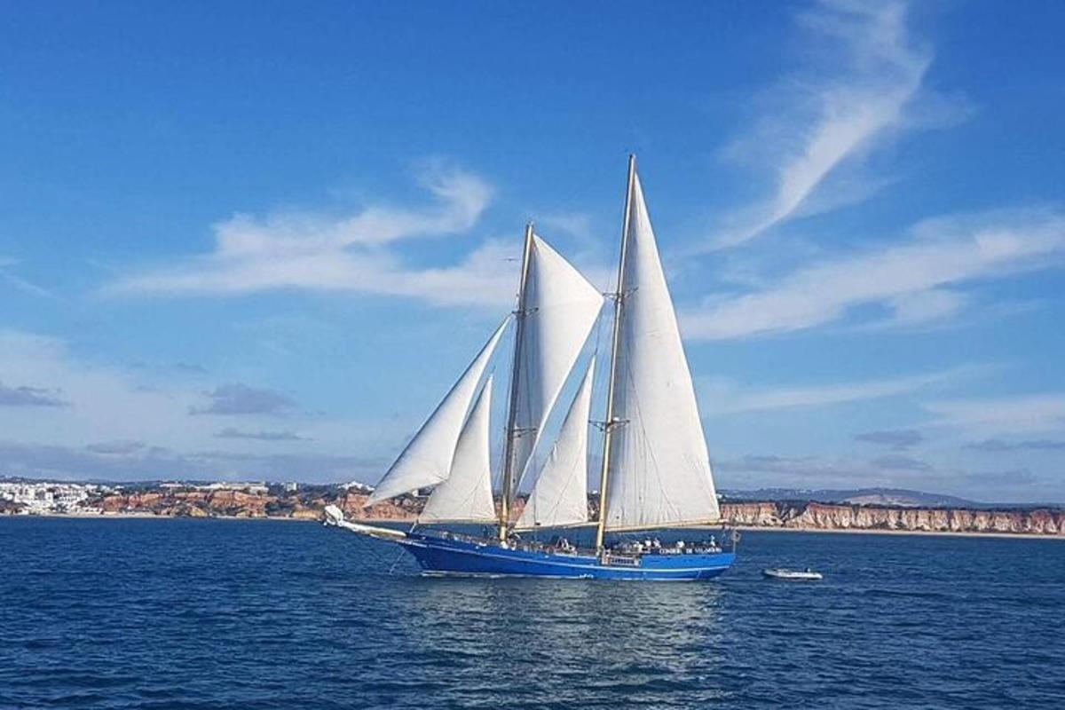 un barco con velas blancas en el agua