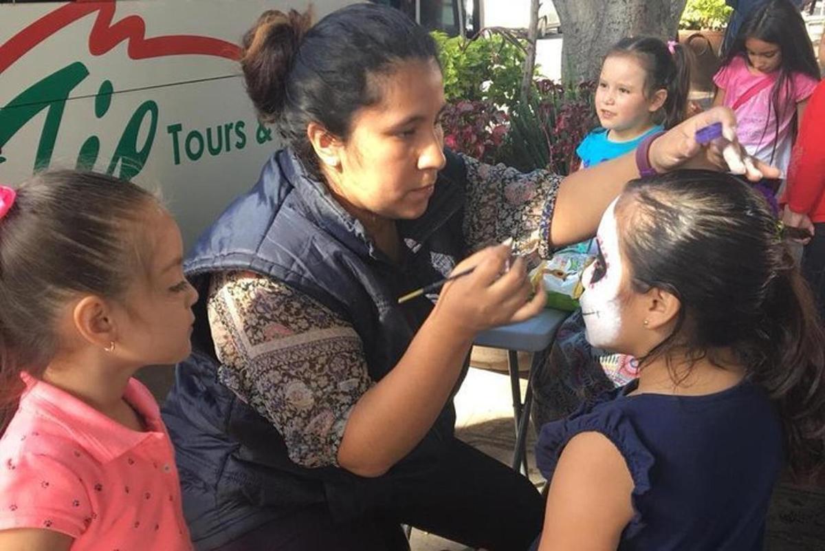 a woman painting a girls face at a hair salon