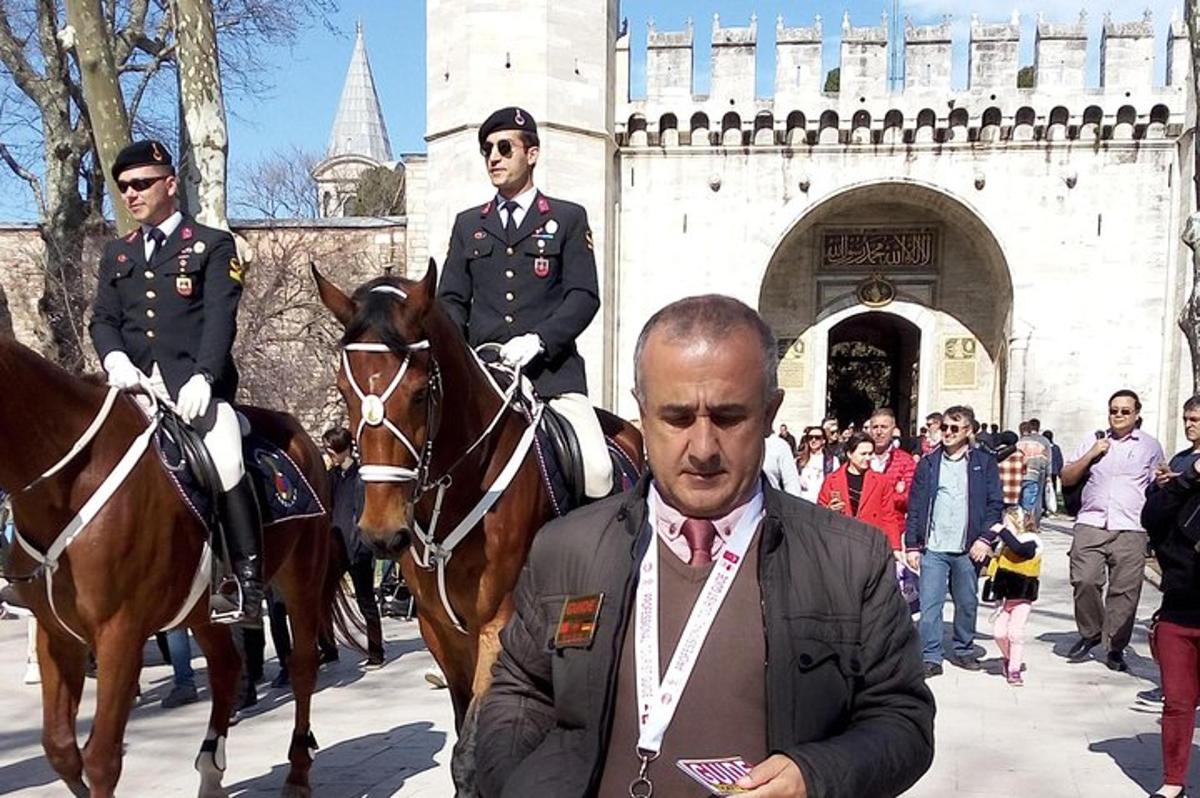 moški v obleki stoji poleg dveh moških na konjih
