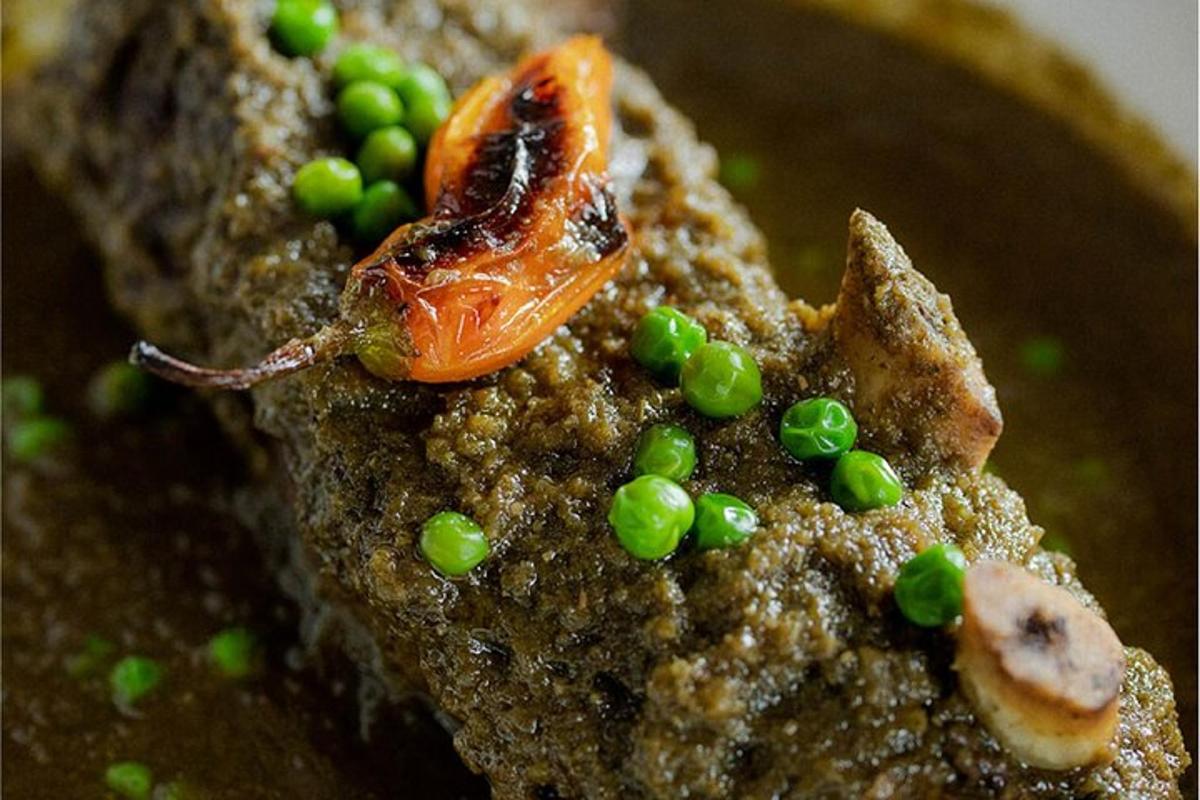 um prato de comida com ervilhas e um pedaço de carne
