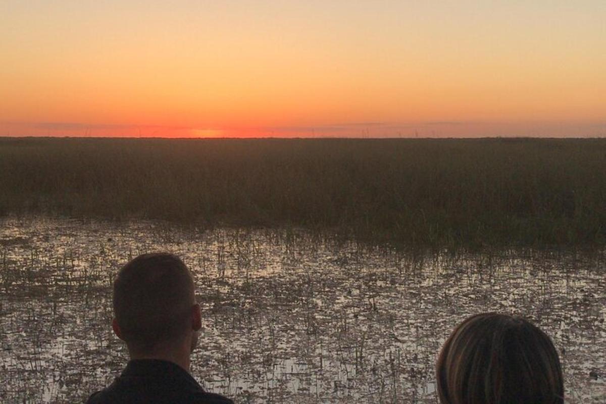 a man and a woman looking at the sunset