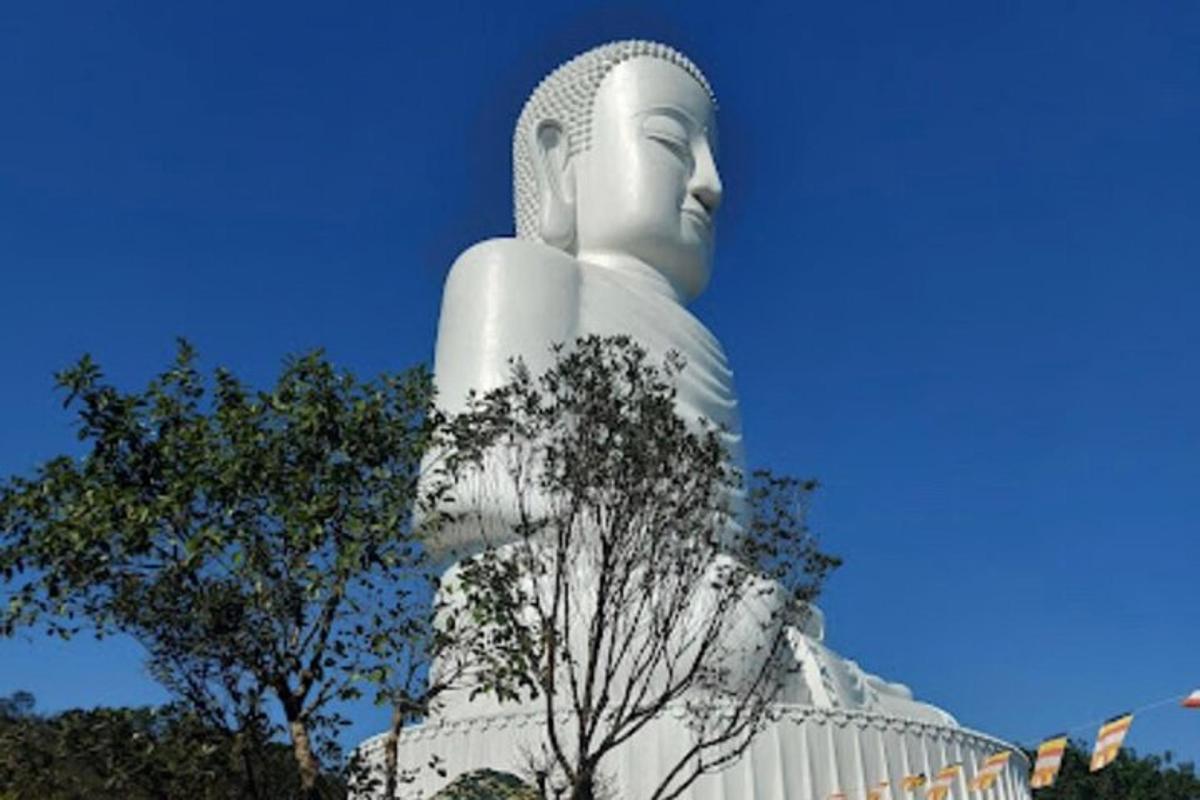 una grande statua di una donna in piedi accanto agli alberi