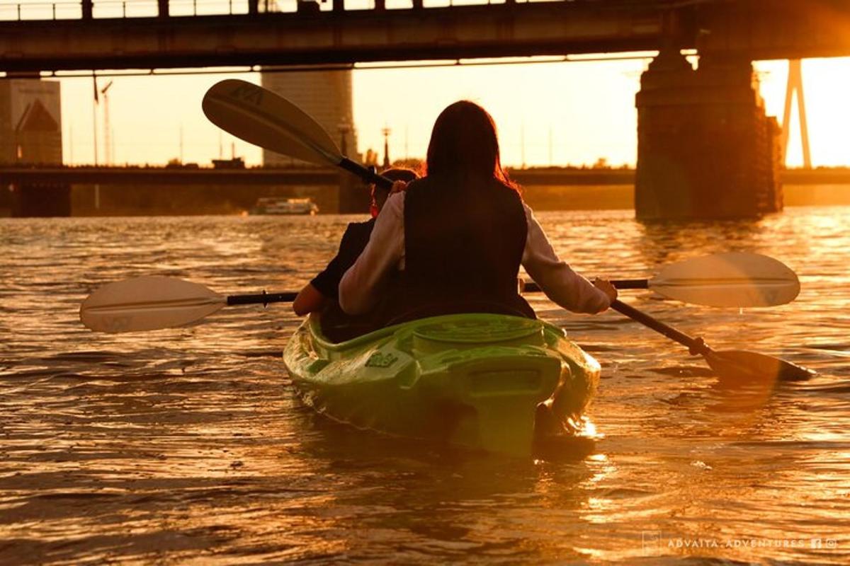 una donna in kayak in acqua vicino a un ponte