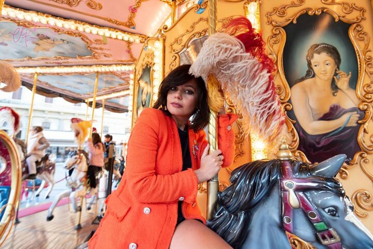 una donna con un vestito arancione seduta su una giostra