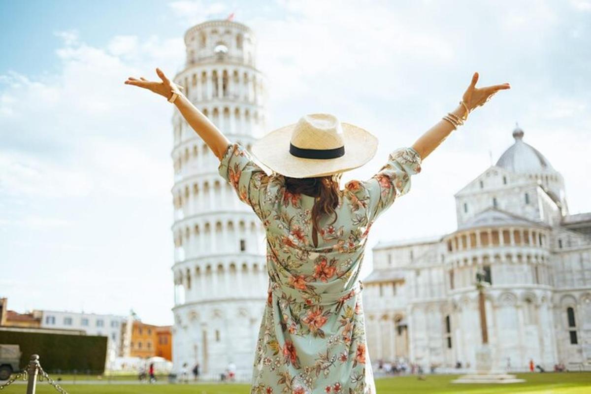 a woman in a hat standing in front of the leaning tower