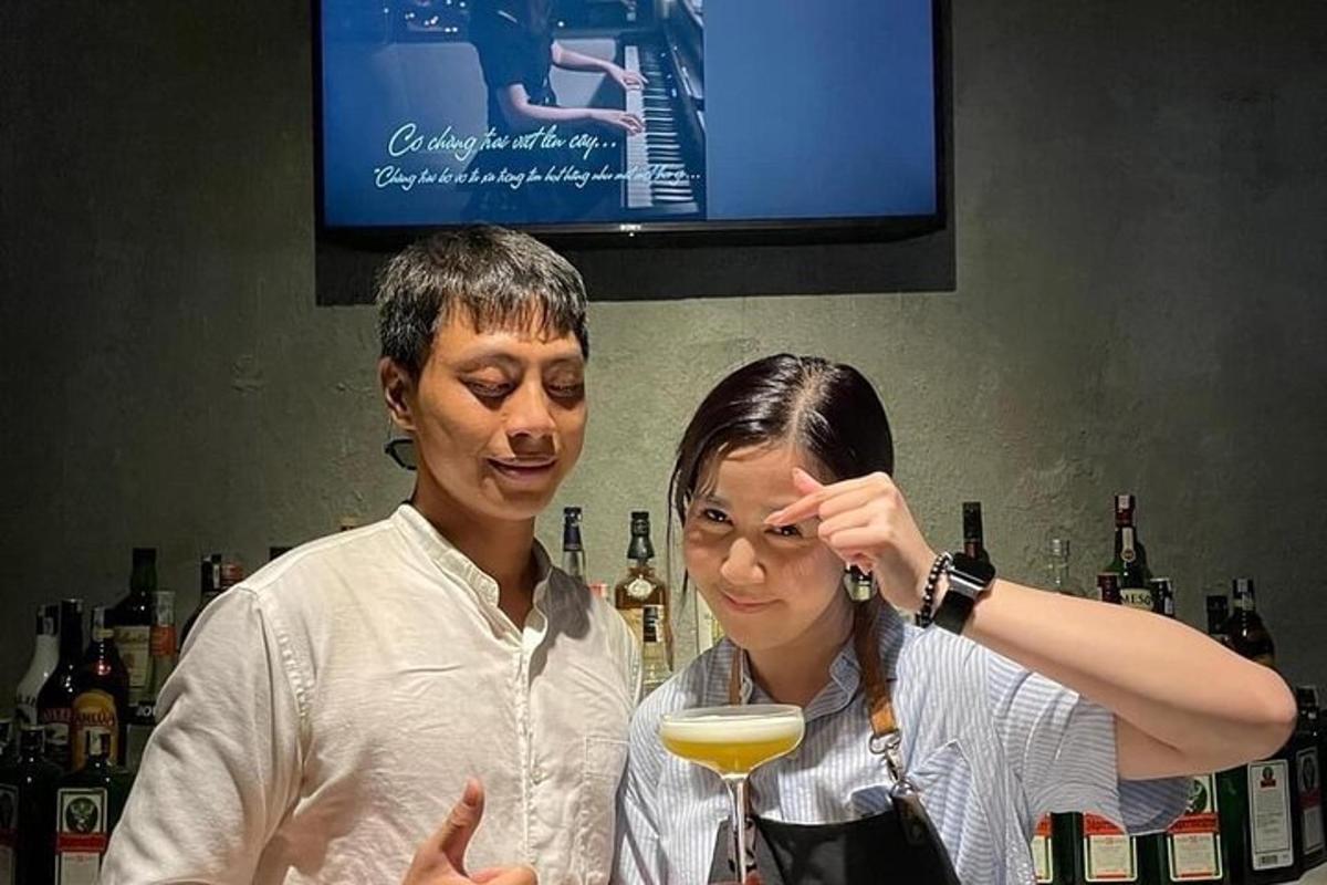 một người phụ nữ đứng cạnh một người đàn ông đang cầm một ly rượu vang