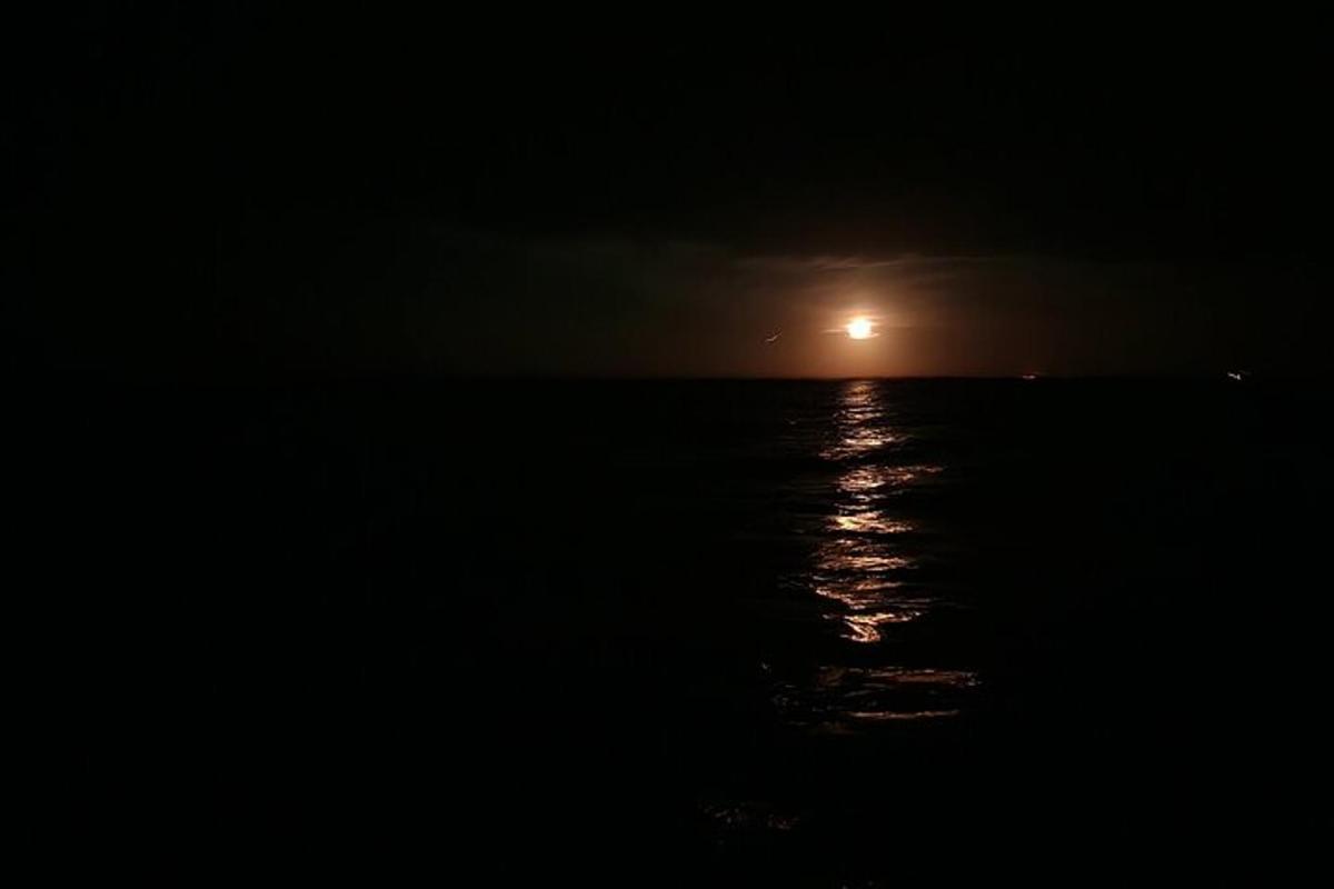 un sorgere della luna sull'oceano di notte