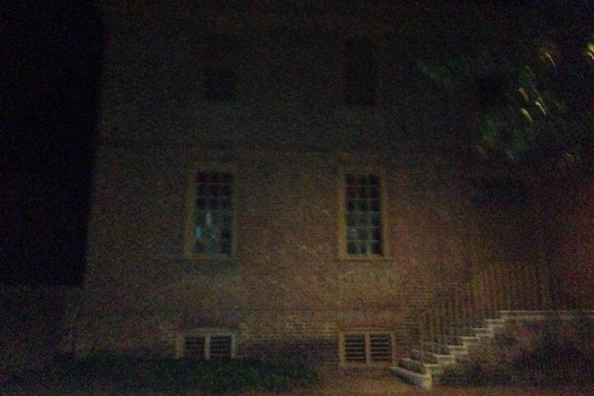 a large brick house at night with stairs in front