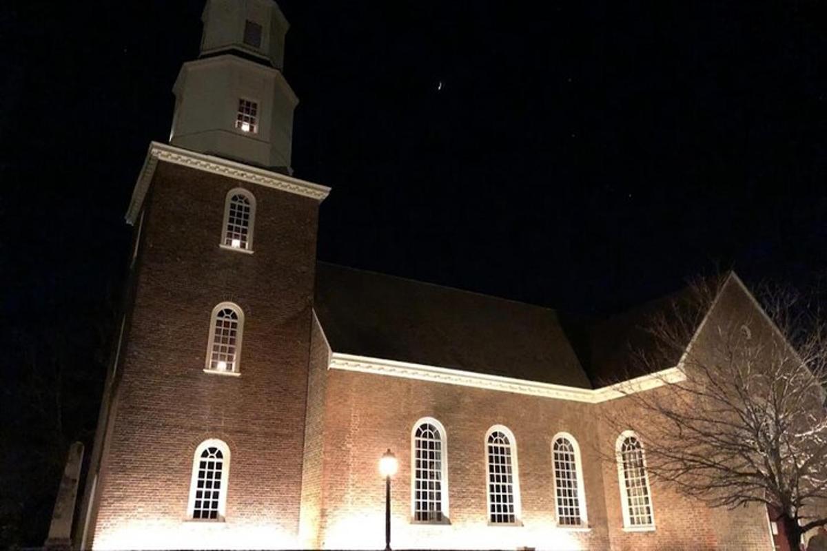 a large brick church with a clock tower at night