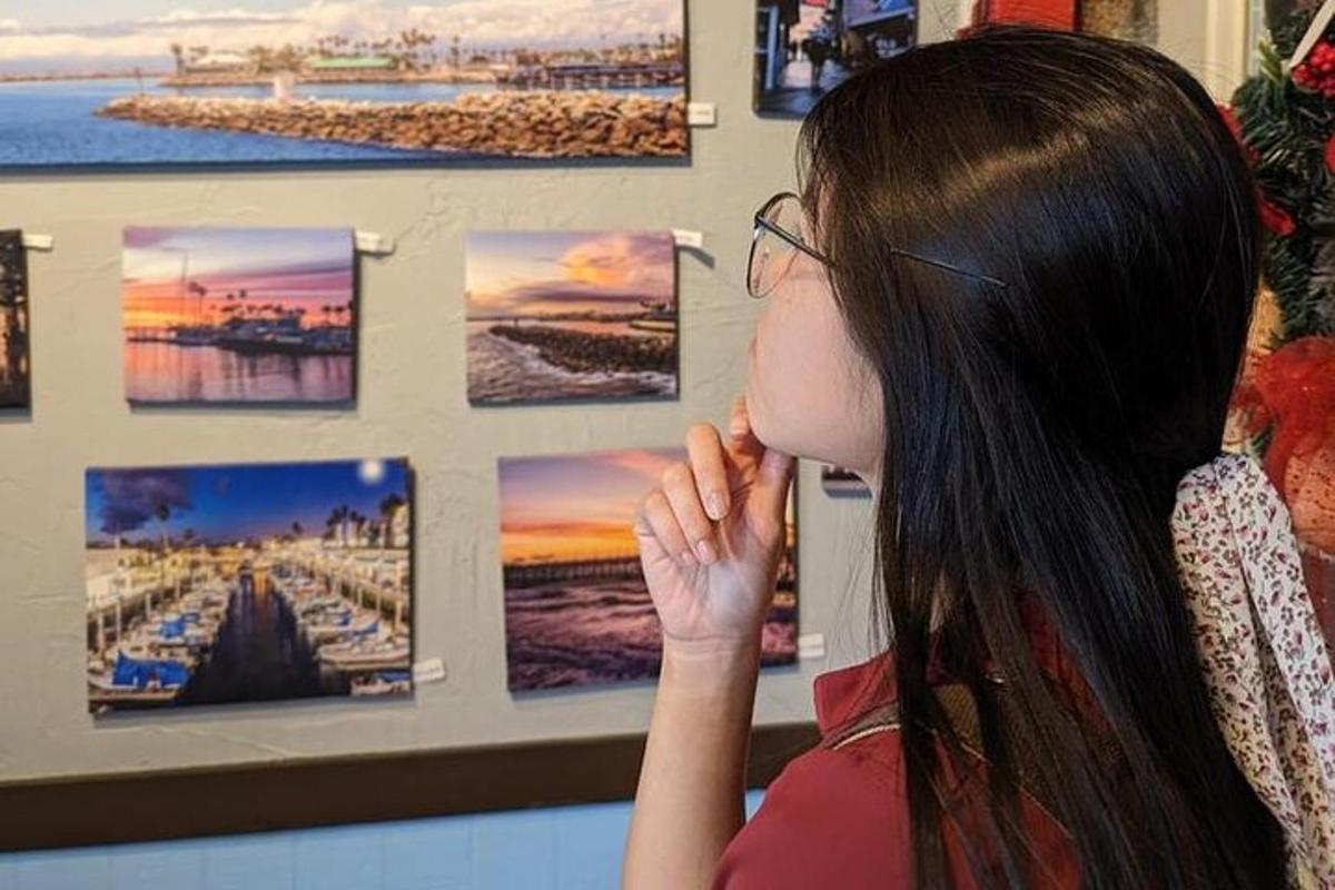 ženska, ki gleda fotografije na steni