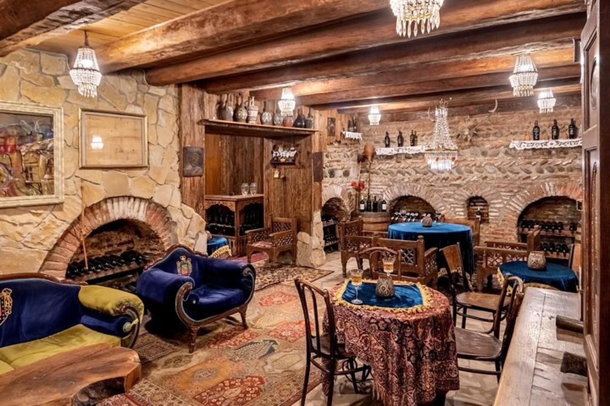 Una sala de estar con chimenea de piedra y mesas y sillas.
