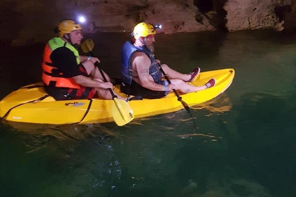 three men in a yellow kayak in the water