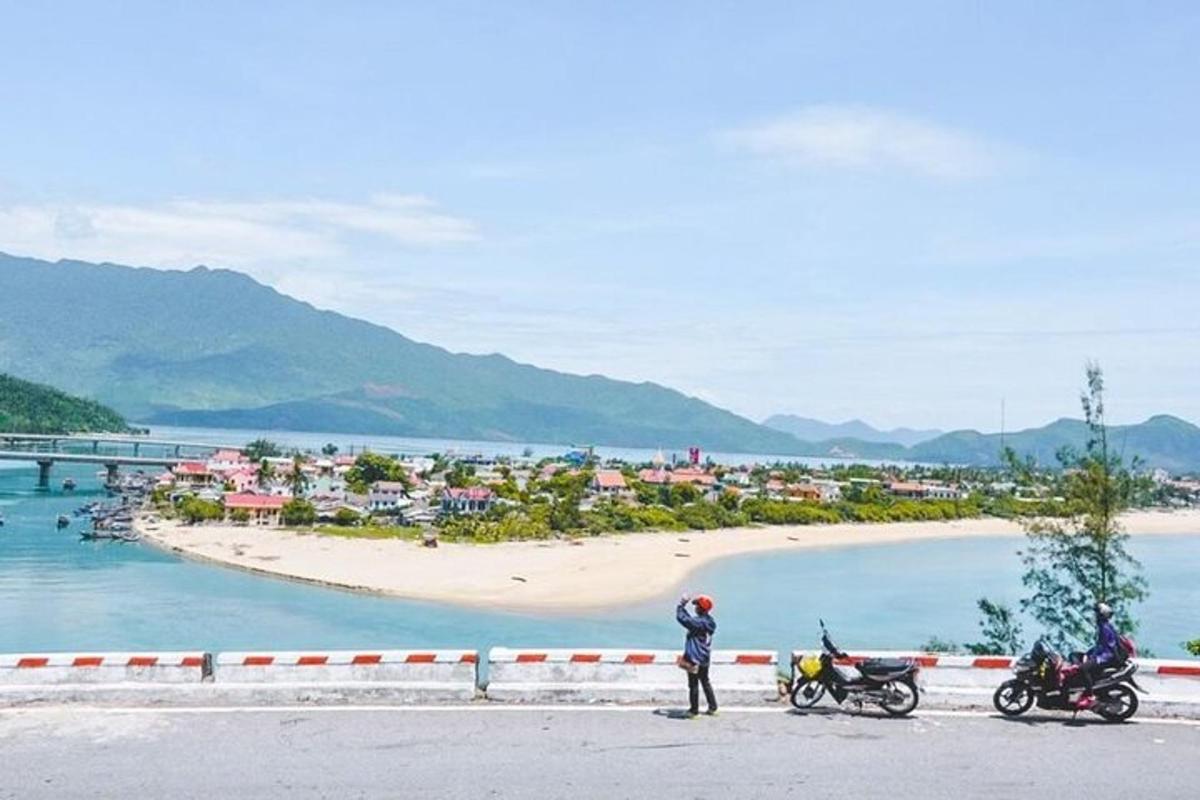 a man standing next to two motorcycles on a beach