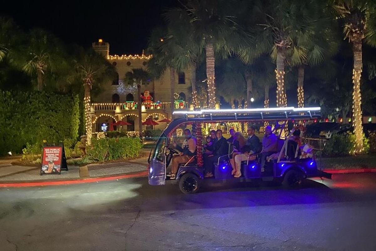 eine Gruppe von Menschen, die nachts mit einem Golfwagen fahren