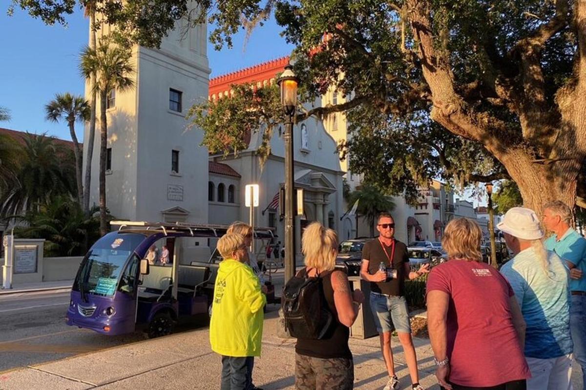 Un grupo de personas paradas en una acera cerca de una calle.