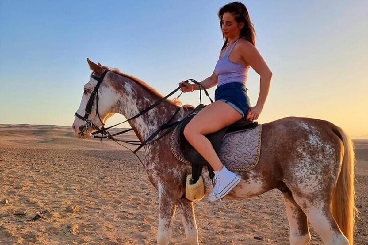 žena jedoucí na koni v poušti
