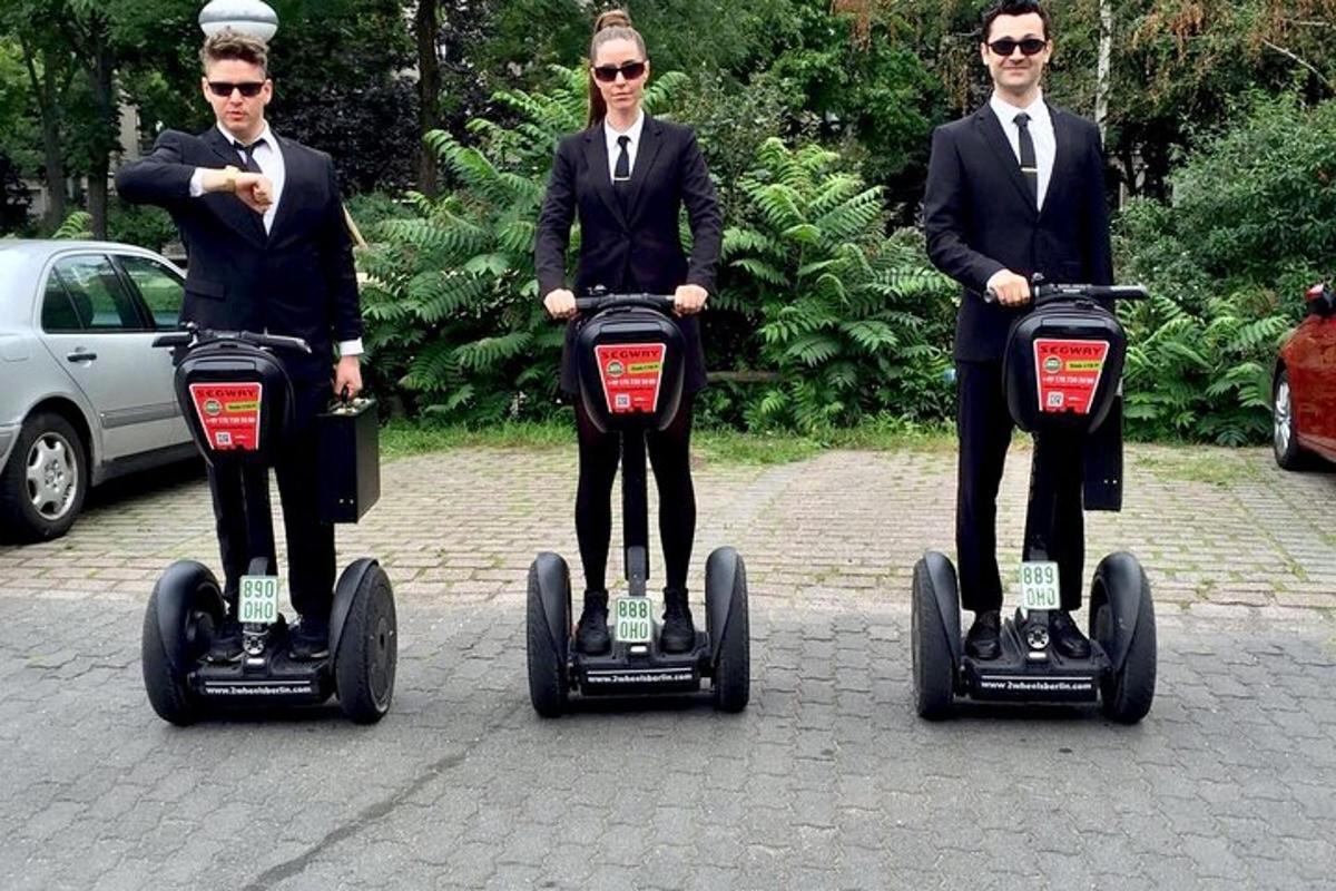 tři lidé v oblecích jedoucí na segiftech
