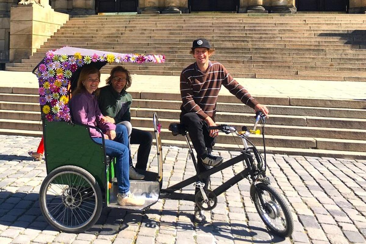 três pessoas sentadas em uma bicicleta com um guarda-chuva