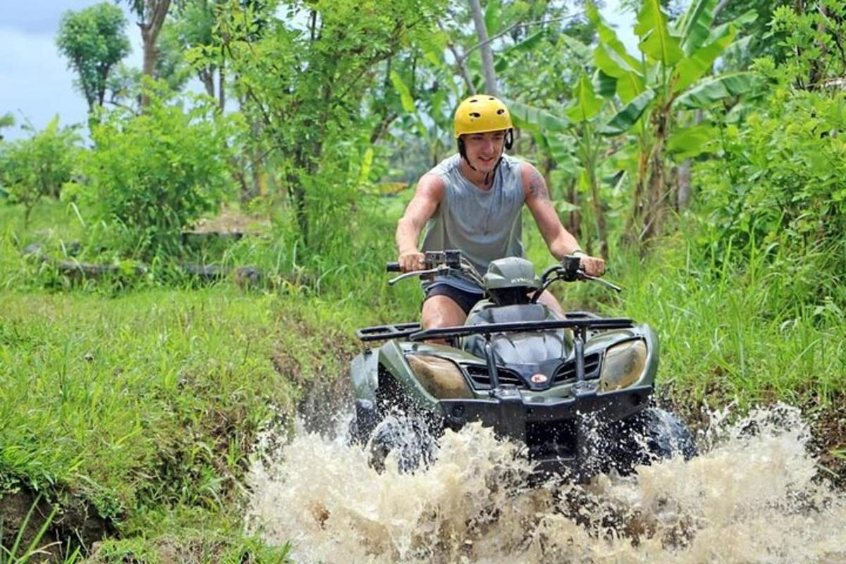 muž jedoucí na čtyřkolce po vodě