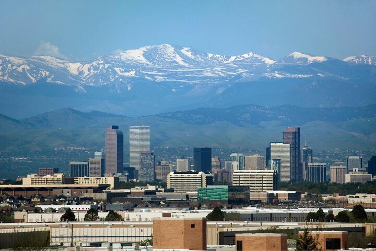 una ciudad con montañas nevadas al fondo