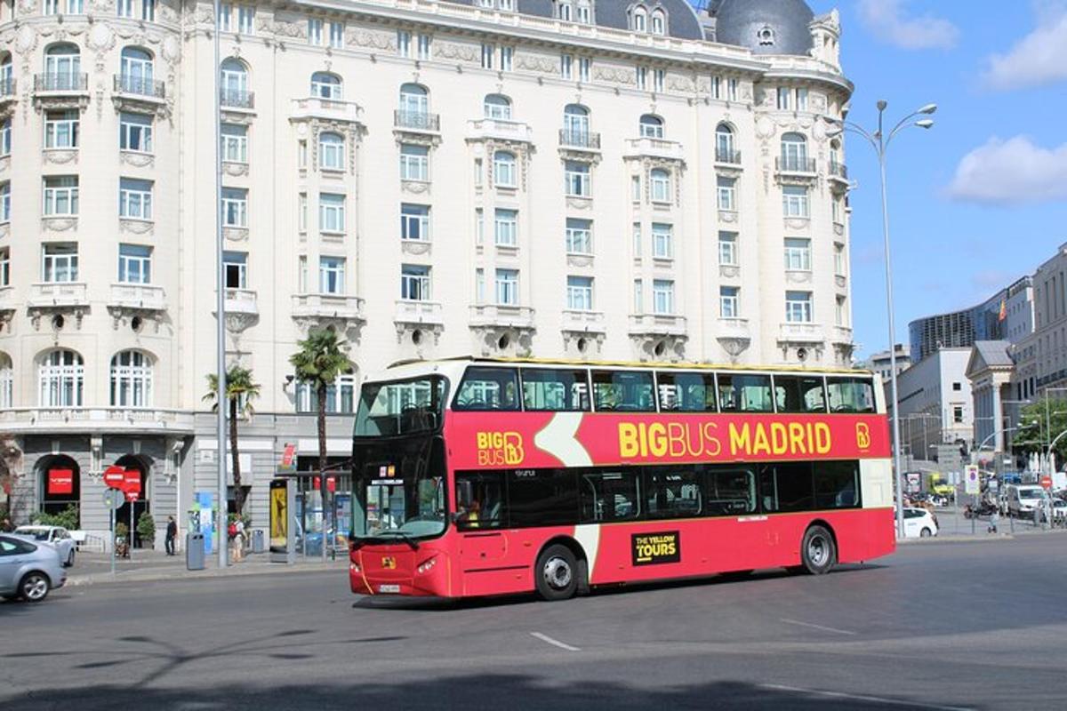 rdeč dvonadstropni avtobus, ki se vozi po mestni ulici
