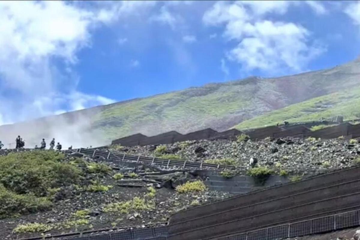 hópur fólks sem stendur á hæð með fjalli