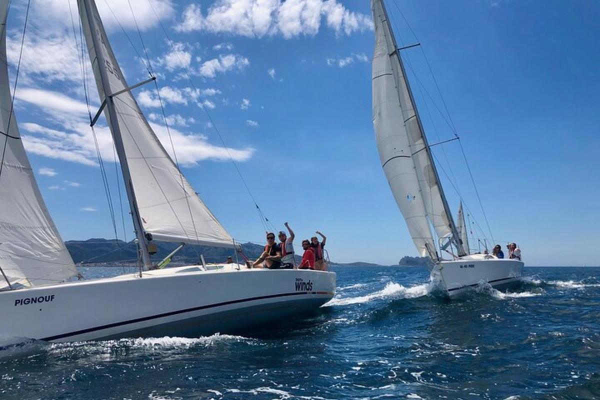 twee zeilboten in het water met mensen erop