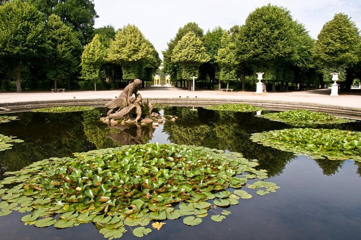 uma piscina de água com uma estátua em um parque