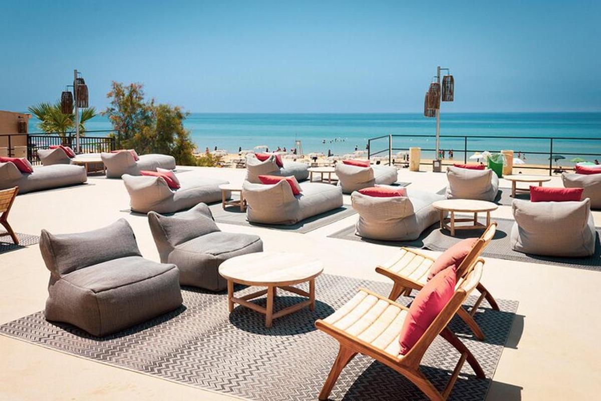 un'area salotto con sedie e tavoli e la spiaggia