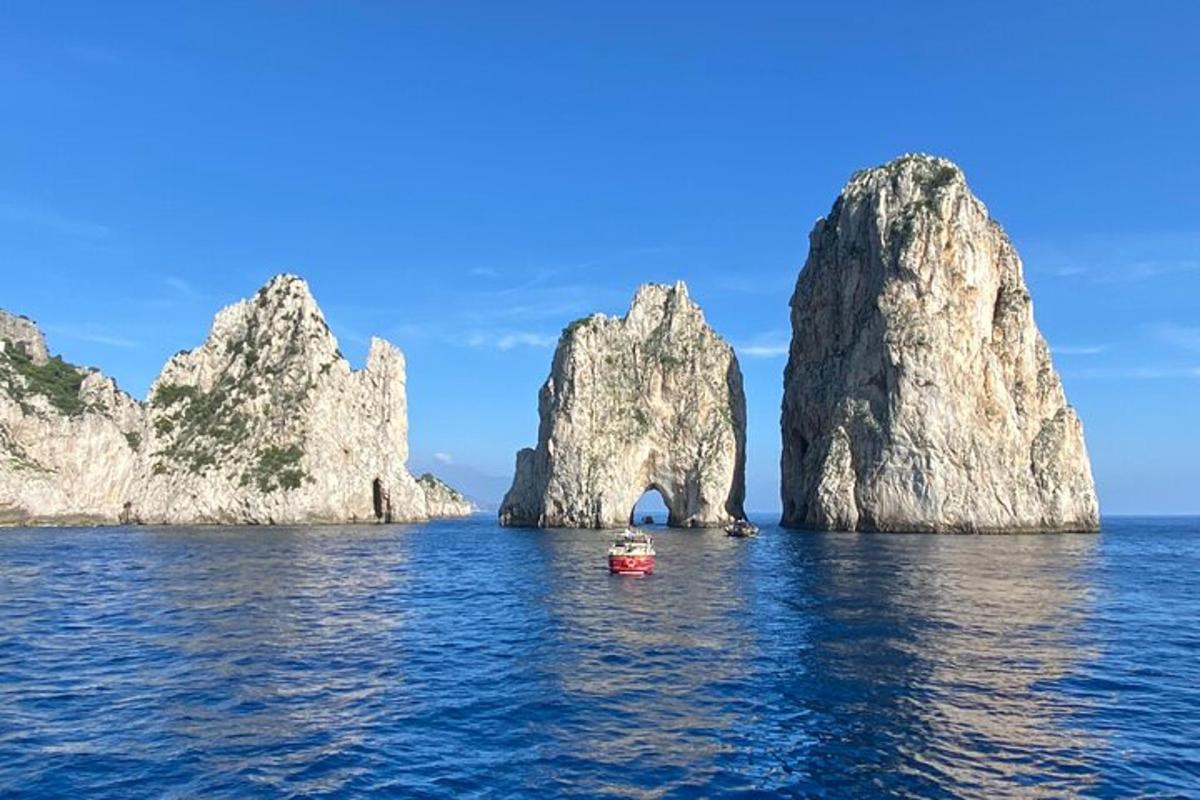 una barca a l'aigua prop d'unes grans roques